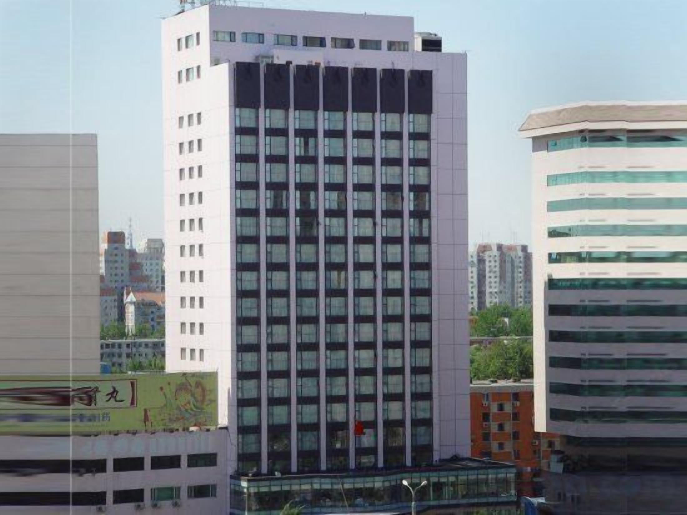 A multi-story building with a modern architectural design, featuring a series of windows and a flat roof.