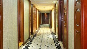 A long, narrow hallway with wooden doors on both sides and a patterned floor. - Jingbin Hotel (Beijing)