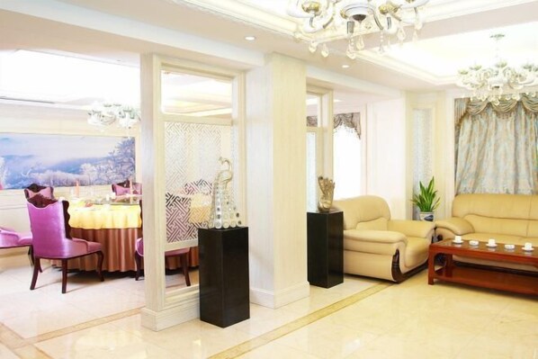 Una sala de estar amplia con un sofá beige, una mesa de centro y un comedor con sillas rosadas y una mesa preparada para cuatro.