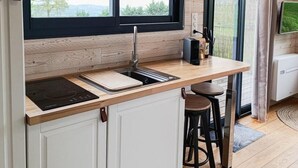 Cocina compacta con un lavamanos integrado, encimeras de madera y ventana con vistas panorámicas.
