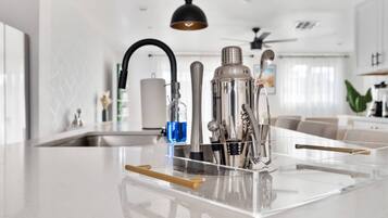A modern kitchen with a central island, stainless steel appliances, and a clear countertop.