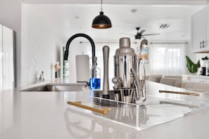 Een moderne keuken met een centraal eiland, roestvrijstalen apparatuur en een opgeruimd aanrecht.