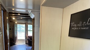 Un pasillo con un banco de madera, un letrero en la pared y una puerta que da a una habitación con vistas.
