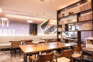 A modern interior with a long wooden table and chairs, a bookshelf, and a wall with a geometric design. - Waiting Qingju Hotel (Shanghai New International Expo Center） (Shanghai)