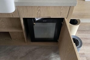 A kitchen with a built-in microwave, a trash bin, and a cabinet. - Waiting Qingju Hotel (Shanghai New International Expo Center） (Shanghai)