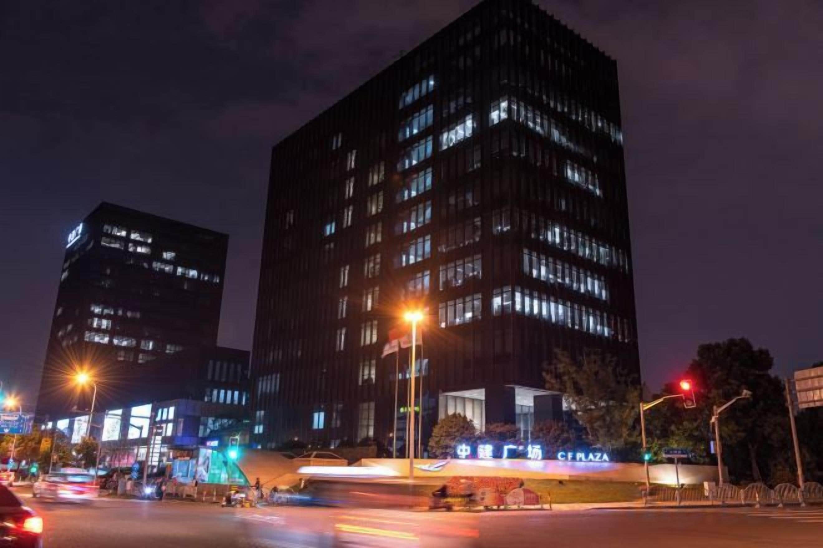 A nighttime cityscape with illuminated buildings and streetlights.