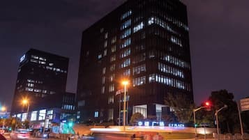 Un paisaje urbano nocturno con edificios iluminados y farolas.