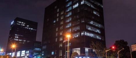 A nighttime cityscape with illuminated buildings and streetlights.