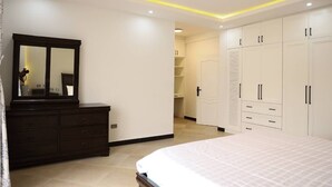 Un dormitorio con cama, cómoda y armario.