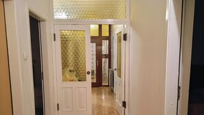 A hallway with a wooden floor, white doors, and a glass door with a bubble pattern. - Cozy Trogir Apartment With 3 Bedrooms (Trogir)