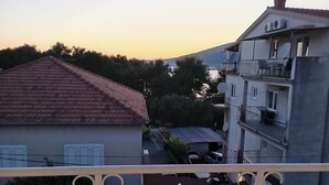 A residential building with a red-tiled roof, a balcony with a white railing, and satellite dishes on the exterior. - Cozy Trogir Apartment With 3 Bedrooms (Trogir)