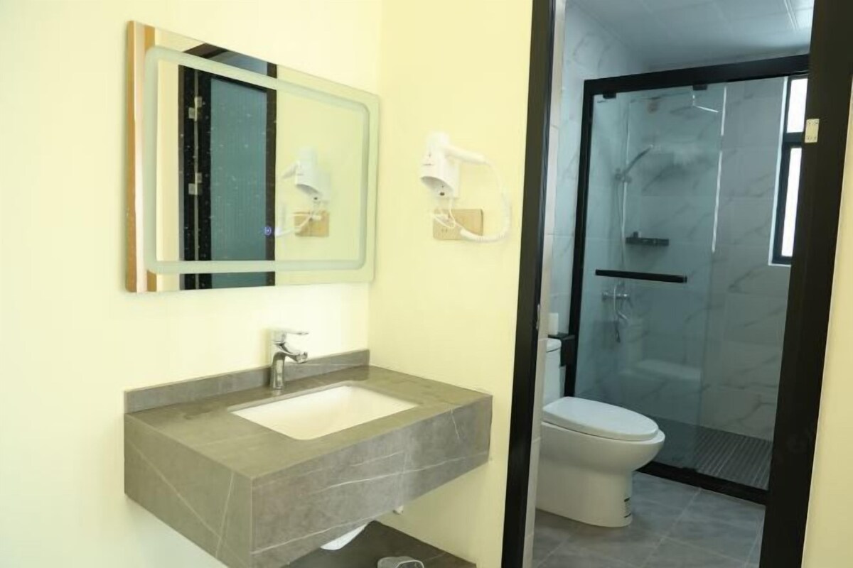 A bathroom with a sink, mirror, and a toilet.