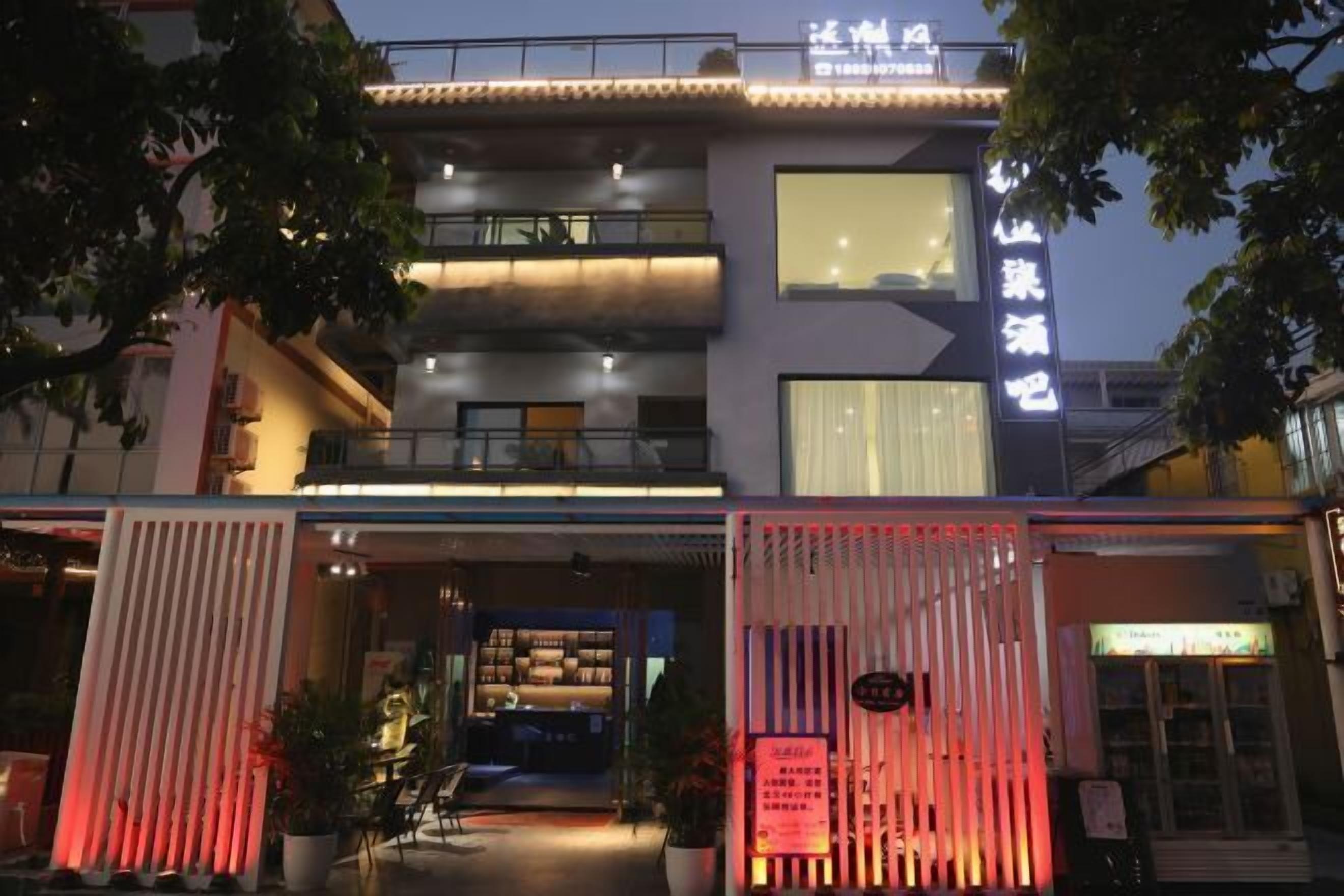 Un bâtiment moderne doté d’une grande entrée, d’une enseigne avec des caractères chinois et d’un balcon.