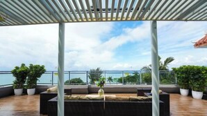 Eine Dachterrasse mit einer Pergola, Sitzgelegenheiten und Kübelpflanzen.