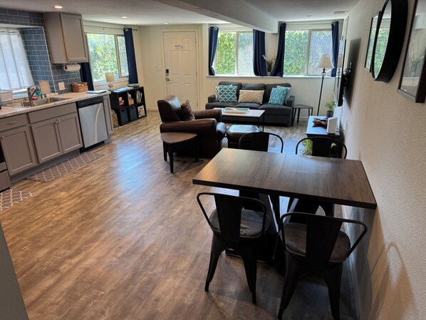 A modern kitchen with a dining area, a sofa, and a coffee table.