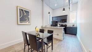A modern kitchen with dark cabinets, a microwave, and a stove.