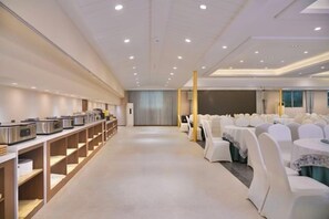 A conference room with rows of tables and chairs, a buffet area, and a stage. - Celebrity Youngsun Xinhua Hotel (Mianyang)