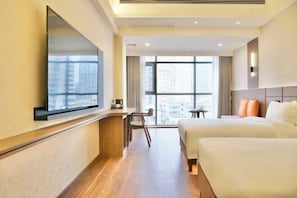 A hotel room with a large window, a desk, two beds, and a mirror. - Celebrity Youngsun Xinhua Hotel (Mianyang)