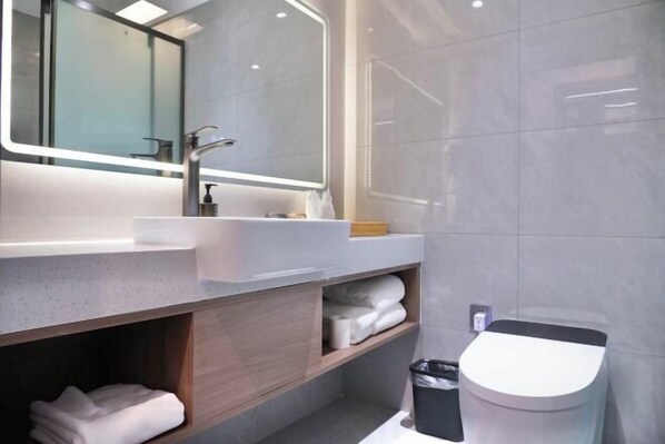 A modern bathroom with a large mirror, a sink, and a toilet. - Celebrity Youngsun Xinhua Hotel (Mianyang)