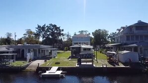 Een woonwijk met huizen, een steiger en een klein bootje.