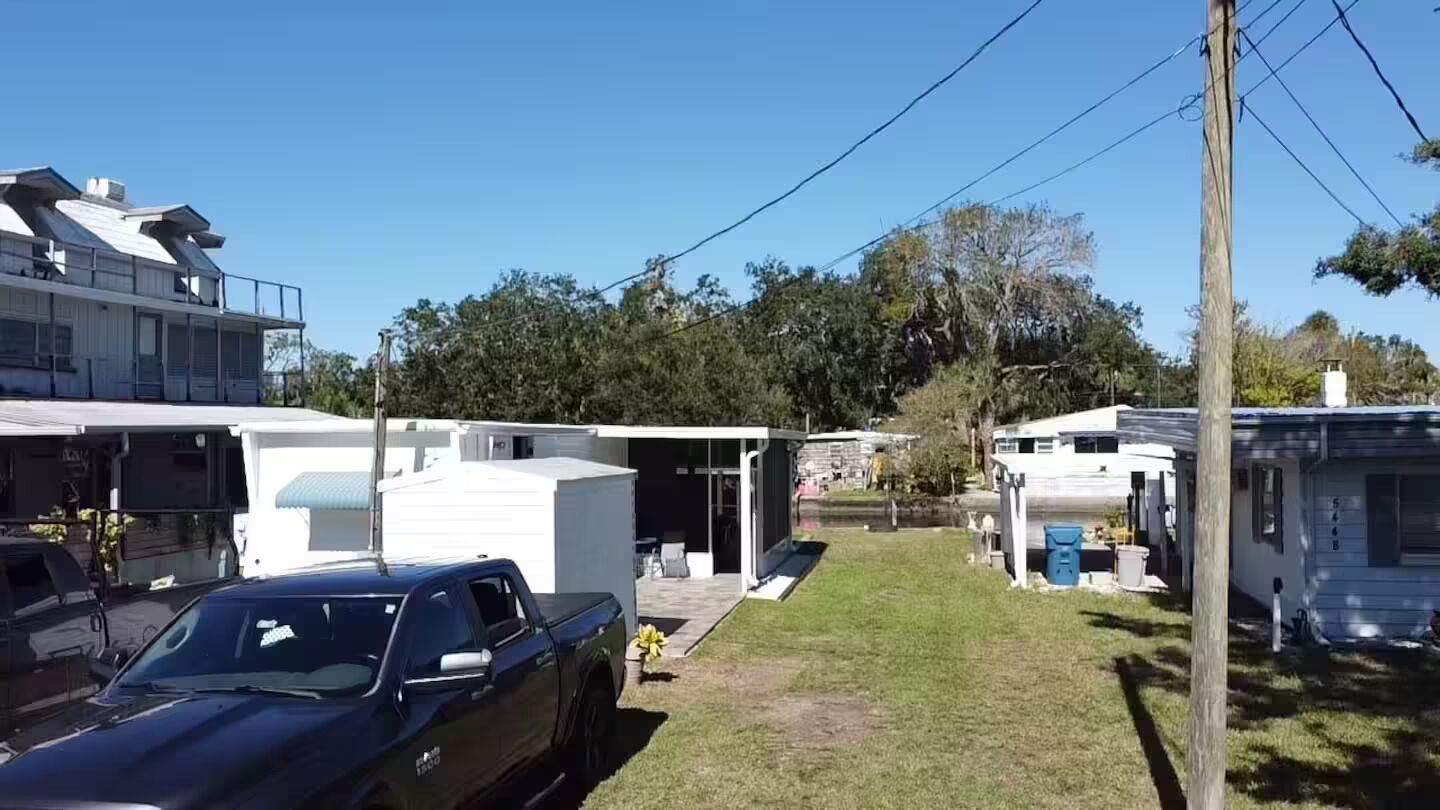 Un quartier résidentiel composé de maisons mobiles, d’un camion garé et d’une pelouse.