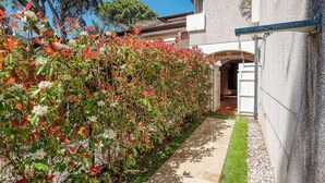 A pathway leading to a building with a stone facade and an arched entrance. - Appartement avec jardin - Cavalière (Le Lavandou)