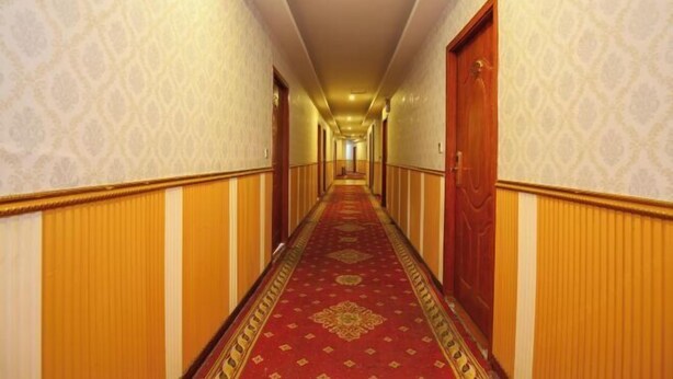 A long, narrow hotel corridor with patterned wallpaper and a red carpet. - Jiazhou Hotel (Chongqing Yiyuan) (Chongqing)