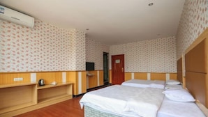 A hotel room with two beds, a wooden wardrobe, a small desk, and a television. - Jiazhou Hotel (Chongqing Yiyuan) (Chongqing)