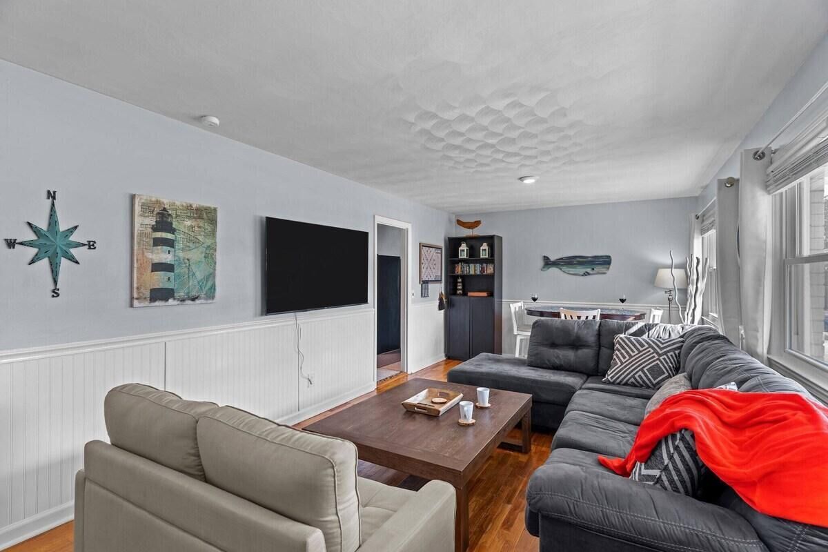 A modern living room with a sofa, coffee table, and artwork on the wall.
