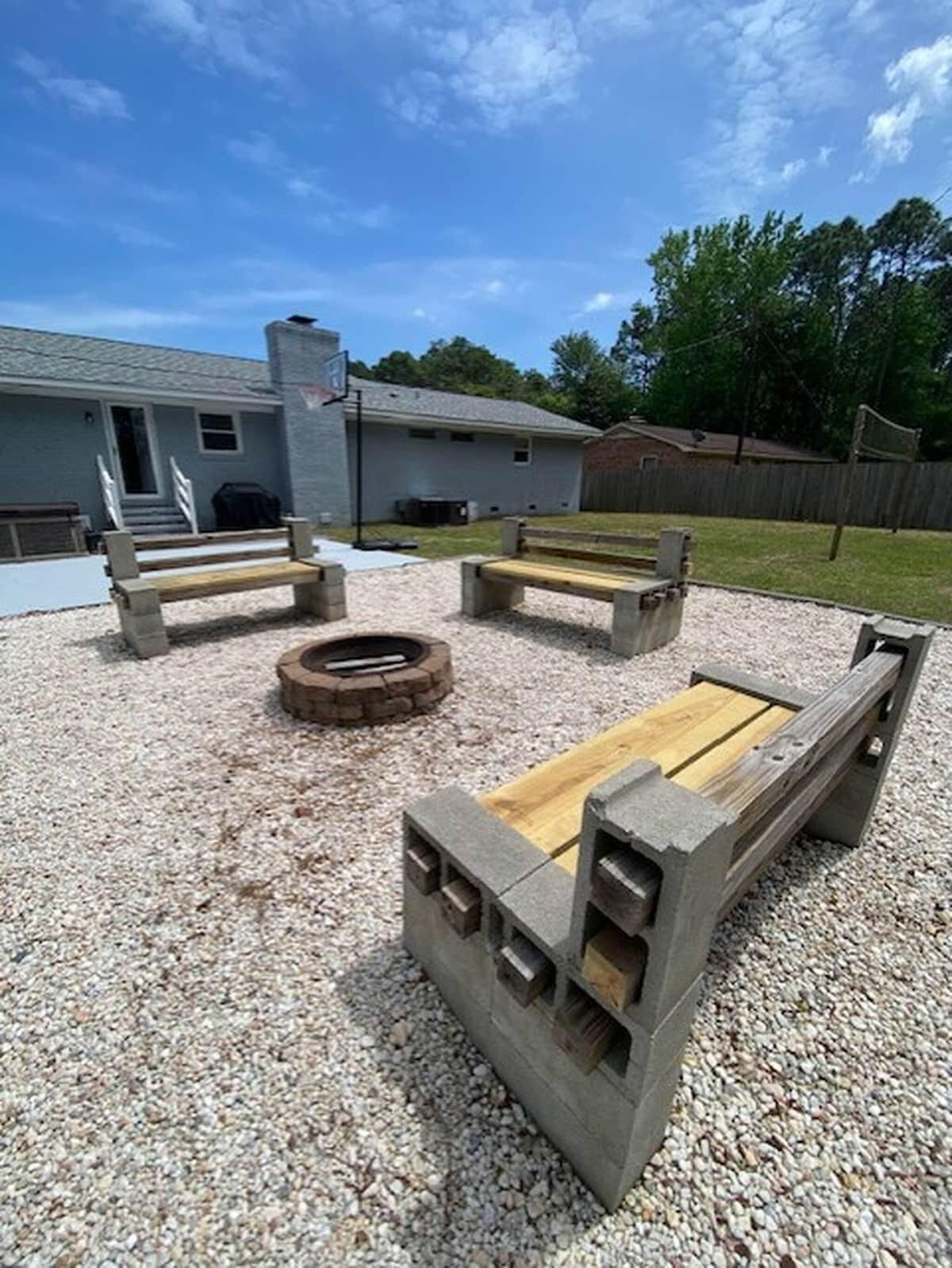 An outdoor seating area with concrete benches and a fire pit.