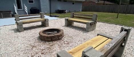 An outdoor seating area with concrete benches and a fire pit.