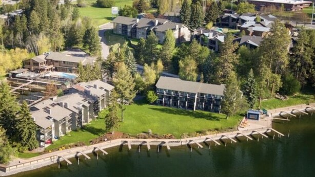 An aerial view of a residential area with houses, a dock, and a body of water.
