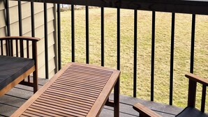 A wooden deck with a view of a lake and trees.