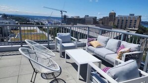 A rooftop terrace with white furniture, including a sofa, chairs, and a table. - Condotel Broadway-E Jefferson-Close to Convention (Seattle)