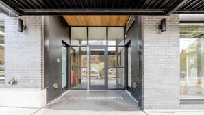 A modern building entrance with a glass door and a wooden ceiling. - Cityscape-Condotel-First Hill (Seattle)