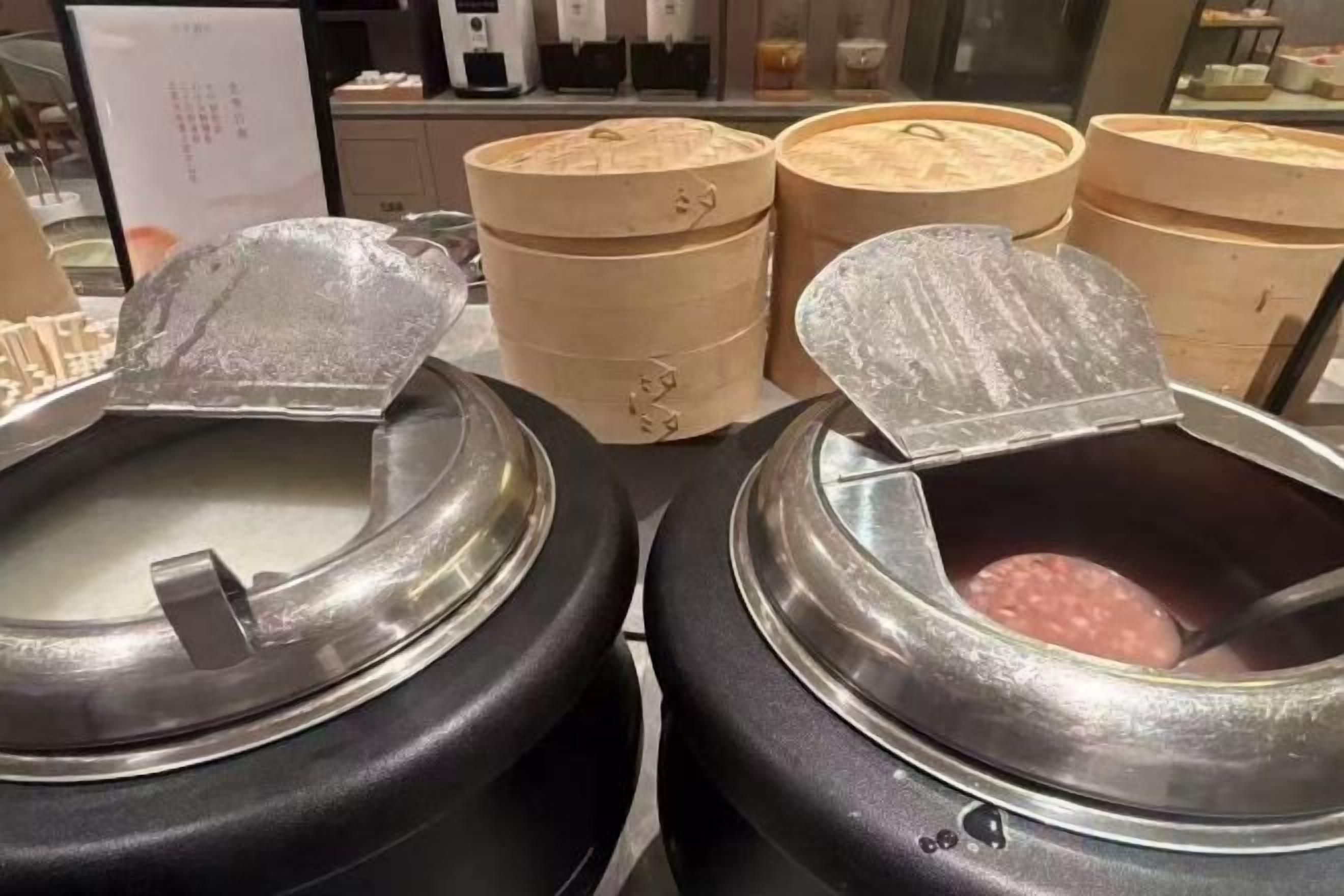 A buffet setup with multiple food containers and serving utensils.