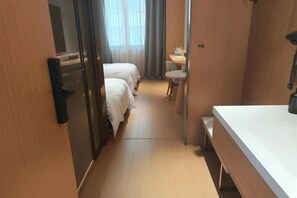 A hotel room with two beds, a small desk, a chair, and a window with curtains. - Yandang Hotel (Wenzhou Teacher Education Institute Yandang) (Yueqing)