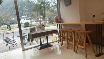 Una habitación con un ventanal grande, una mesa de madera y una zona de bar.