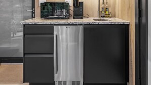 Une cuisine moderne équipée d’un lave-vaisselle intégré, d’une machine à café et d’une cave à vin.