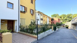 Una calle residencial con casas, aceras y un farol.
