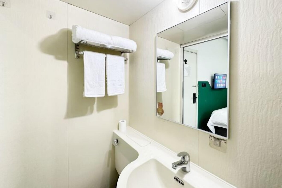 A bathroom with a sink, mirror, and towel rack.
