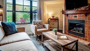 A cozy living room with a fireplace, a sofa, a chair, and a coffee table. - Condo at Mtn Creek  sleep 4 Mountain view 1 Bdr 1 Bath #234 (Vernon Township)
