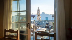 A room with a large sliding glass door leading to an outdoor patio area with wooden furniture and a table.