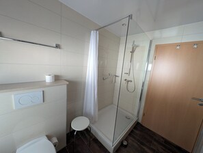 Chuveiro, secador de cabelo, toalhas de banho, papel higiênico