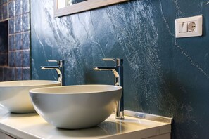Une salle de bain avec deux vasques blanches et un miroir au-dessus.
