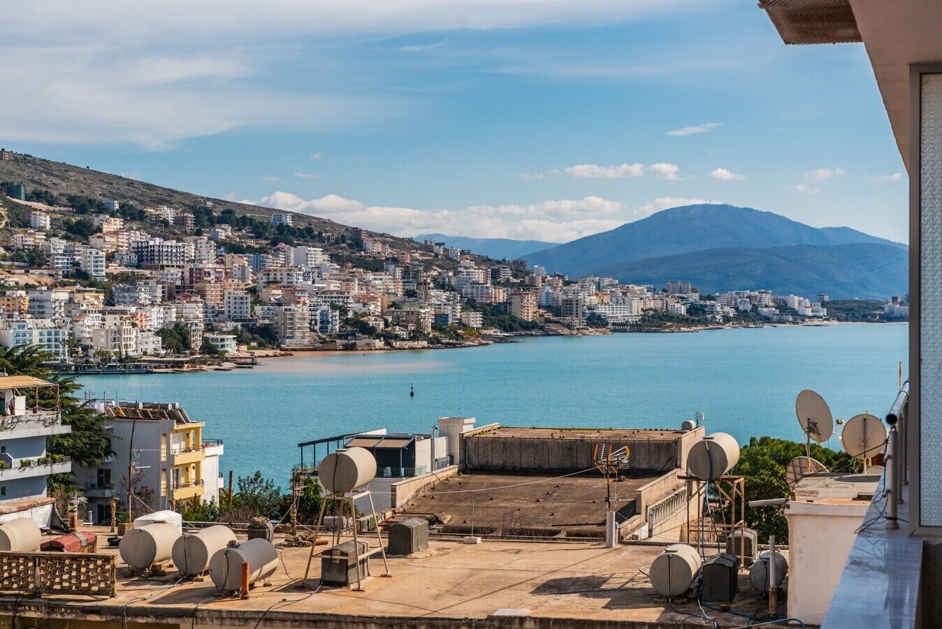Un paysage urbain situé sur la côte, avec vue sur la mer et les montagnes.