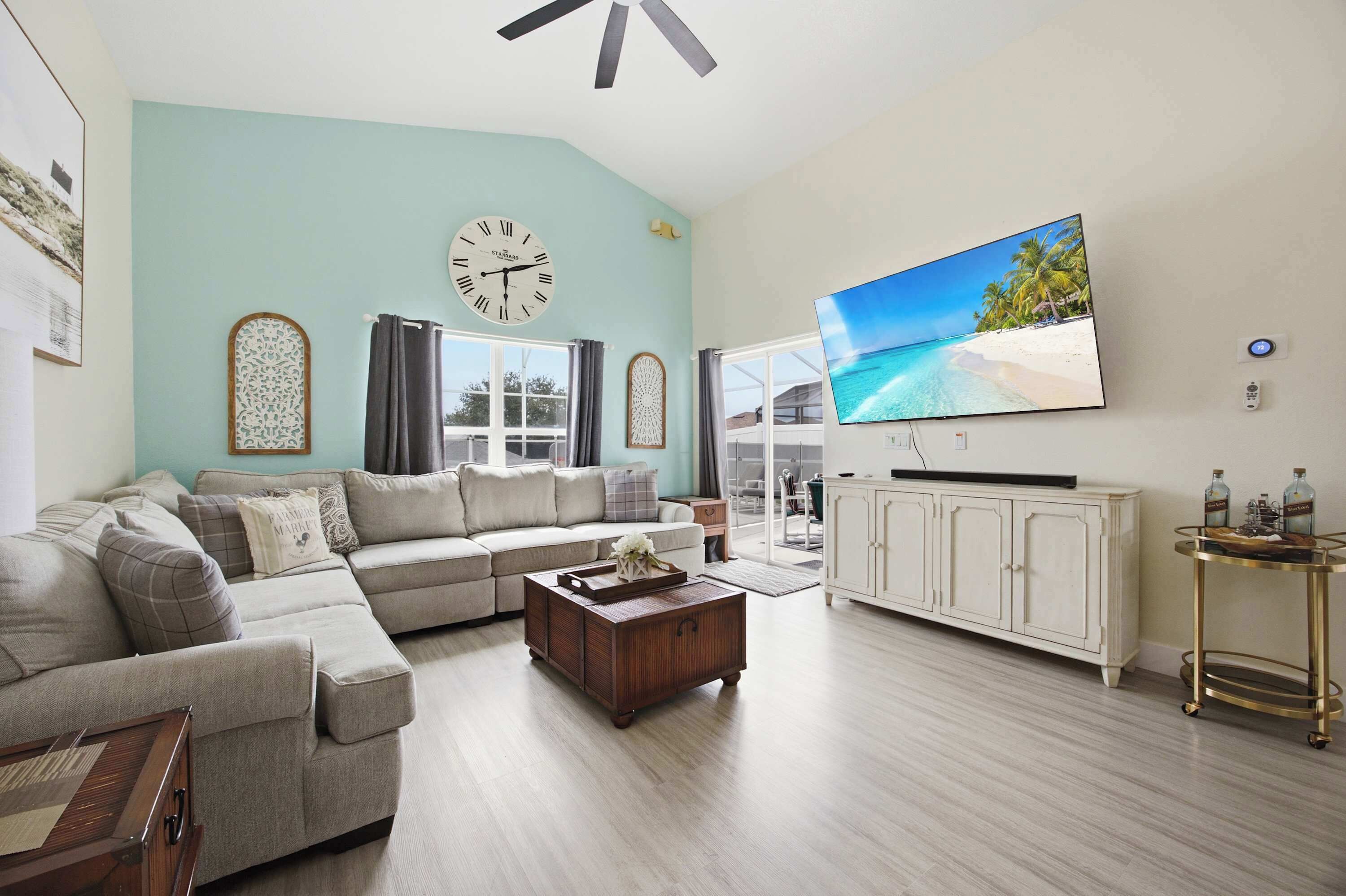 A living room with a sofa, coffee table, and a TV mounted on the wall.