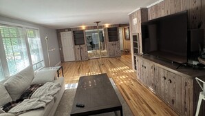 A modern living room with a sofa, a coffee table, and a TV. - Luxury West 7th Fort Worth Stay - Balcony • W/D (Fort Worth)