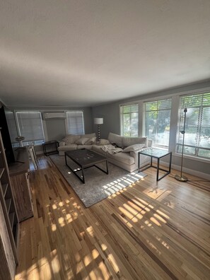 A modern living room with a sofa, coffee table, and floor lamp. - Luxury West 7th Fort Worth Stay - Balcony • W/D (Fort Worth)