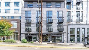 Un edificio de varios pisos con un diseño moderno, con balcones y ventanas amplias.